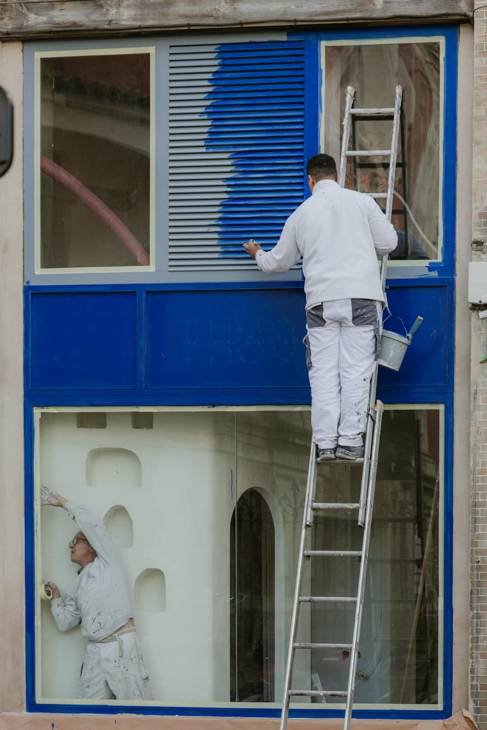 Painters working on a building facade during renovation.