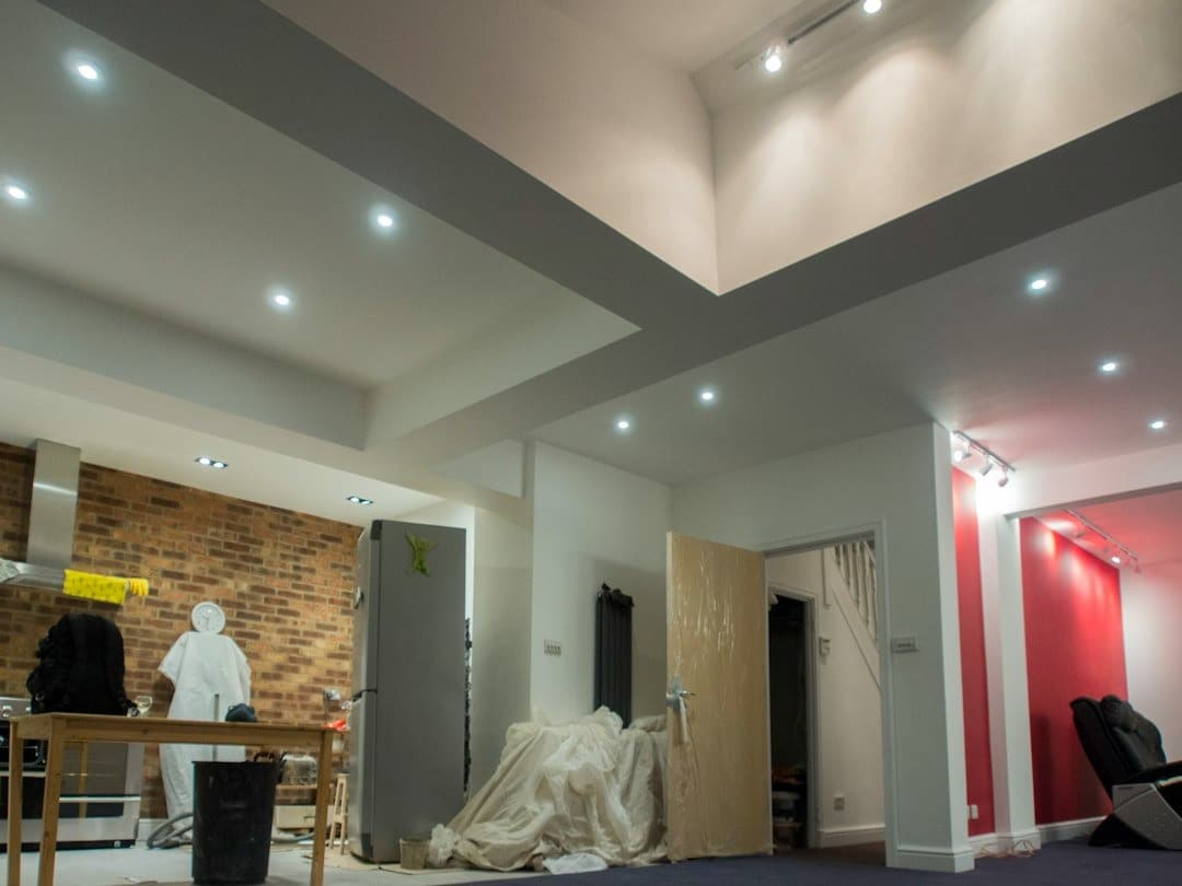 Kitchen space undergoing renovation with exposed brick and construction materials.